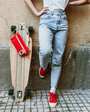 Lade das Bild in den Galerie-Viewer, Frau mit Longboard sitzt auf Treppe mit YKRA Fanny Pack Bauchtasche in rot