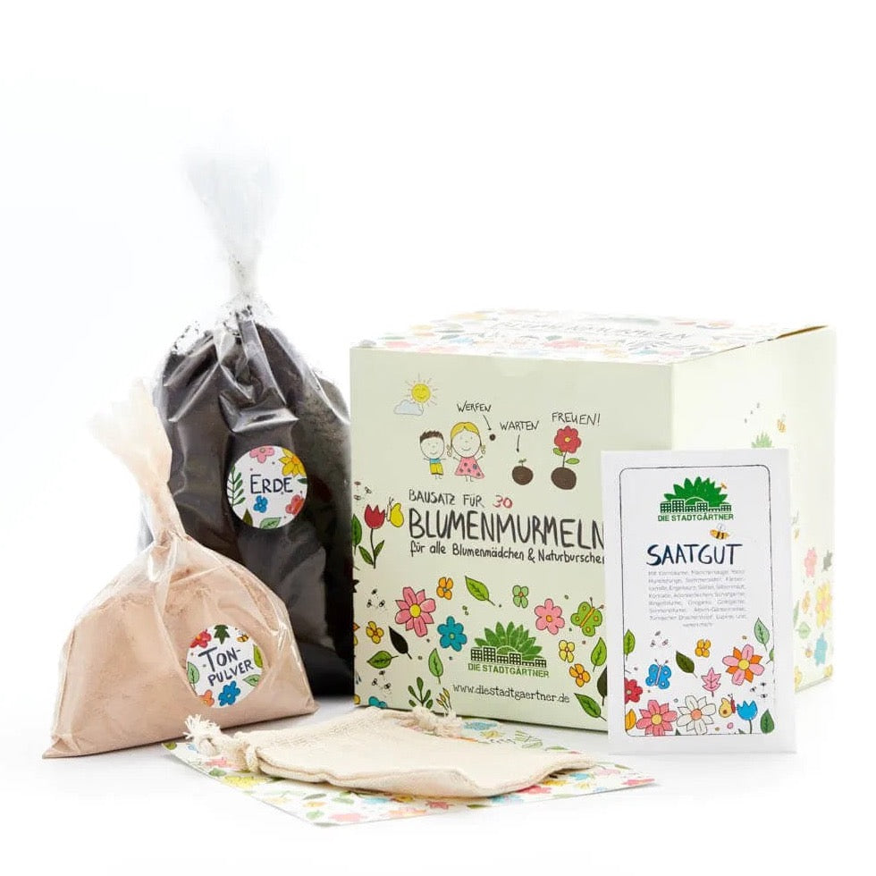 Blumenmurmeln Bausatz, ausgepackter Inhalt mit Erde, Tonpulver, Saatgut und Stoffbeutel