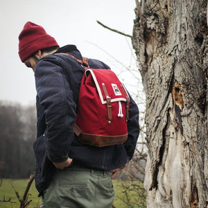 Mann mit roter Mütze und blauer Jacke trägt Ykra Wanderrucksack Matra Mini