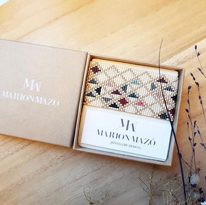 Handgewebtes Perlenarmband der Designerin Marion Mazo, mehrfarbiges geometrisches Muster, Armband eingepackt in geöffneter Schachtel
