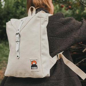 Frau mit weißem YKRA Scout Rucksack auf dem Rücken